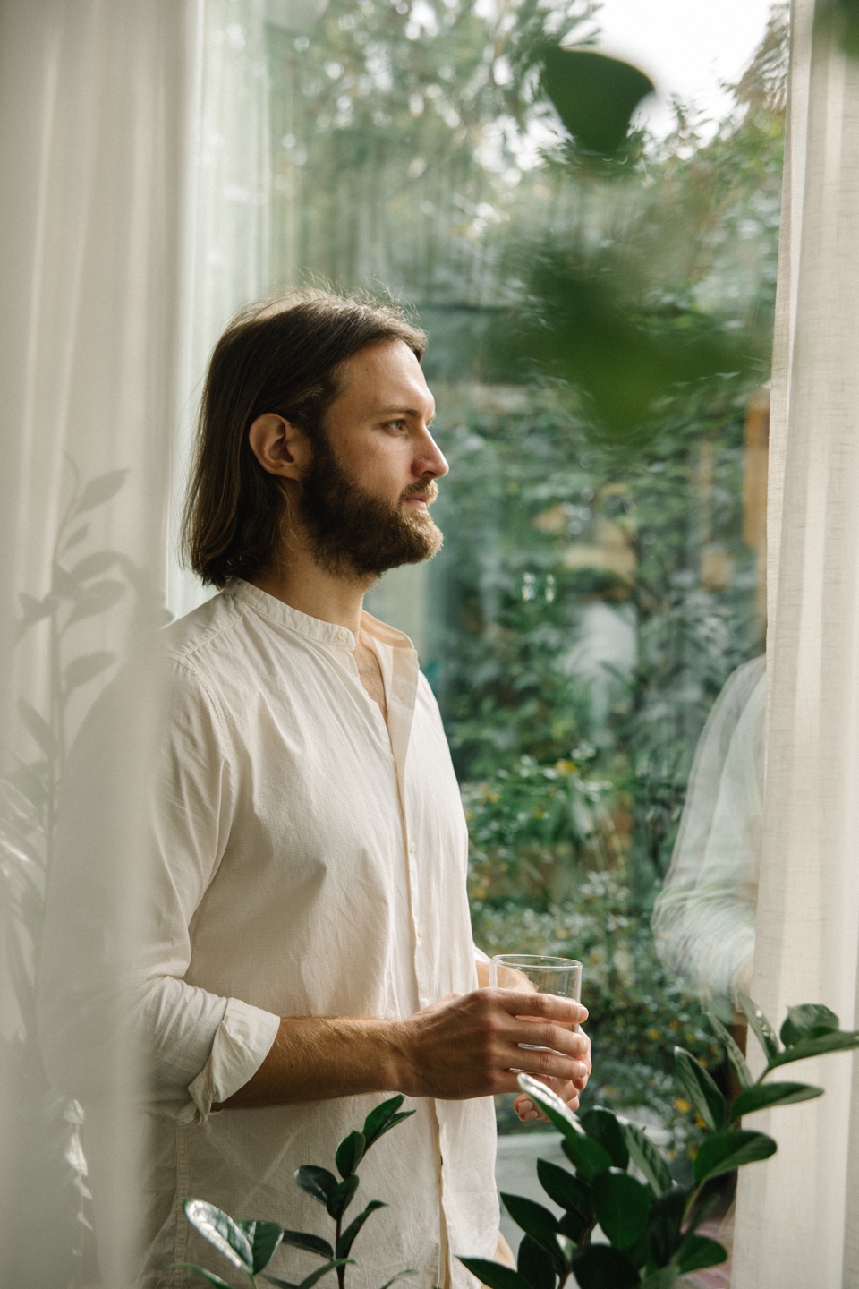 Pavel im weißen Hemd am Fenster mit Blick ins Grüne